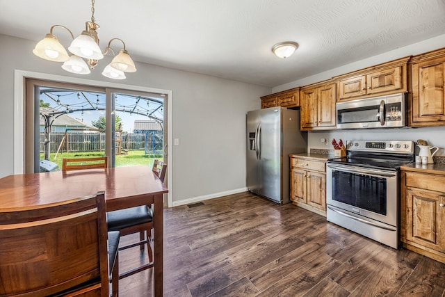 701 Lexington Cir, Clever, MO 65631 - kitchen with stainless steel appliances, a chandelier, dark wood-style flooring, brown cabinetry, and decorative light fixtures