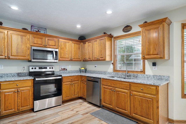 431 S Yellowwood Dr, Springfield, MO 65809 - kitchen featuring appliances with stainless steel finishes, light wood-style floors, brown cabinets, light stone countertops, and recessed lighting