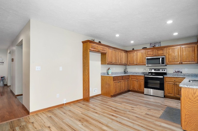 431 S Yellowwood Dr, Springfield, MO 65809 - kitchen featuring stainless steel appliances, brown cabinets, light wood-style flooring, recessed lighting, and light stone counters