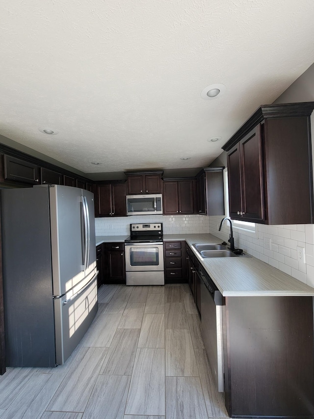 100 Hawthorn Ave, Rogersville, MO 65742 - kitchen with appliances with stainless steel finishes, light countertops, backsplash, and dark brown cabinetry