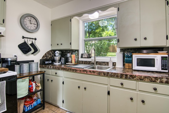 135 Roark Ave, Branson, MO 65616 - kitchen with white microwave, electric stove, dark countertops, backsplash, and light tile patterned floors