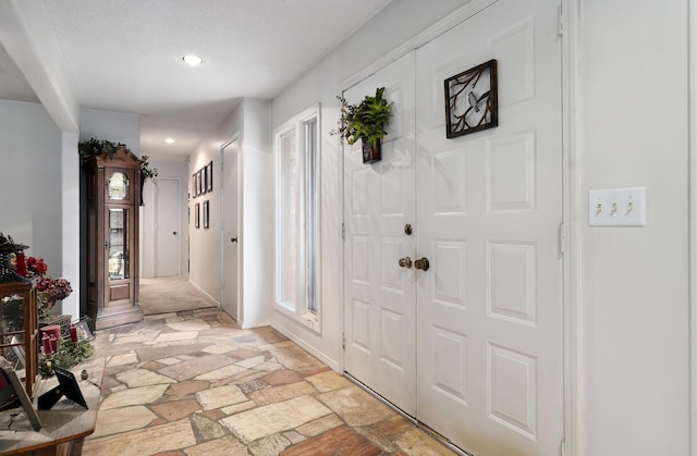 667 S Broadview Dr, Springfield, MO 65809 - entryway featuring light stone finish floors, recessed lighting, and a textured ceiling