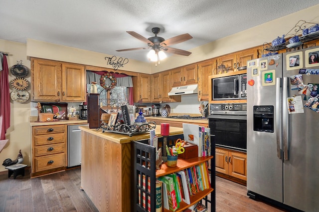667 S Broadview Dr, Springfield, MO 65809 - kitchen with appliances with stainless steel finishes, under cabinet range hood, a ceiling fan, wood finished floors, and a textured ceiling