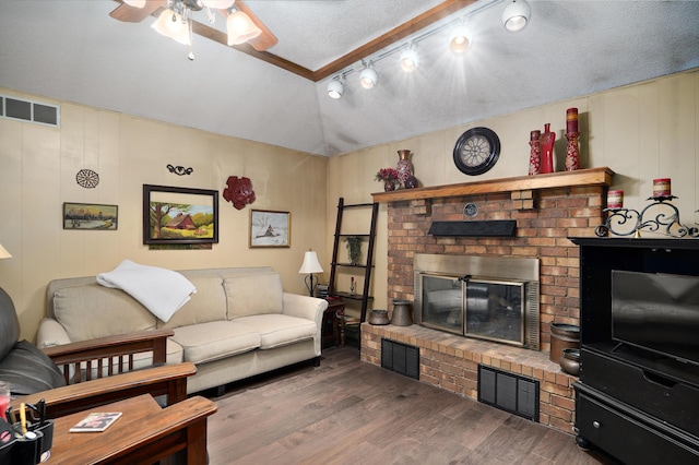 667 S Broadview Dr, Springfield, MO 65809 - living room with ceiling fan, vaulted ceiling, a brick fireplace, wood finished floors, and a textured ceiling