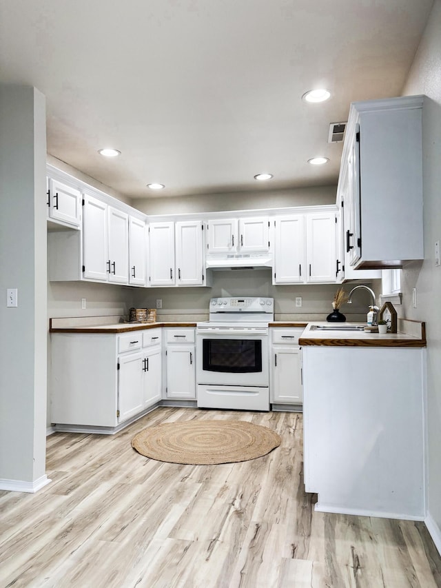 905 NW Blvd, Neosho, MO 64850 - kitchen with electric stove, under cabinet range hood, light wood-type flooring, white cabinetry, and recessed lighting