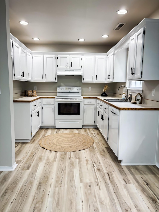 905 NW Blvd, Neosho, MO 64850 - kitchen featuring white appliances, under cabinet range hood, light wood-style floors, white cabinetry, and recessed lighting