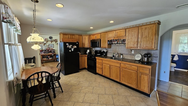 5143 State Highway 95, Drury, MO 65638 - kitchen featuring black appliances, dark countertops, brown cabinetry, decorative backsplash, and arched walkways