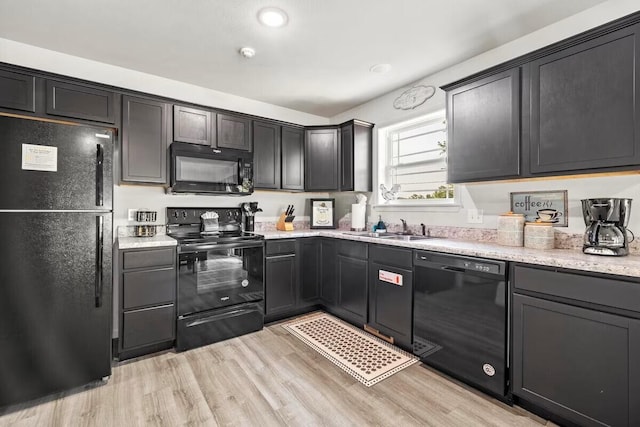 310 W College St, Branson, MO 65616 - kitchen featuring black appliances, light wood-style flooring, and light stone countertops