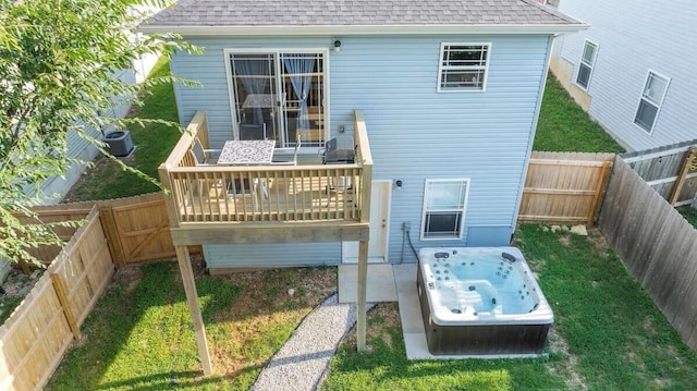 310 W College St, Branson, MO 65616 - back of property with a hot tub, a wooden deck, roof with shingles, and a fenced backyard