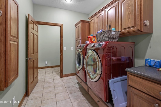 318 Fox Fire Ct, Joplin, MO 64801 - laundry area featuring cabinet space, washing machine and dryer, light tile patterned floors, and a textured ceiling