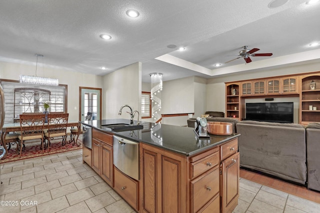 318 Fox Fire Ct, Joplin, MO 64801 - kitchen with ceiling fan, a textured ceiling, dishwasher, brown cabinets, and a kitchen island with sink