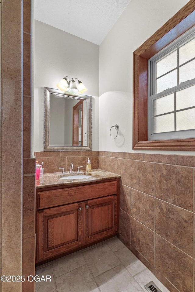 318 Fox Fire Ct, Joplin, MO 64801 - bathroom with vanity, tile walls, tile patterned floors, and a wainscoted wall