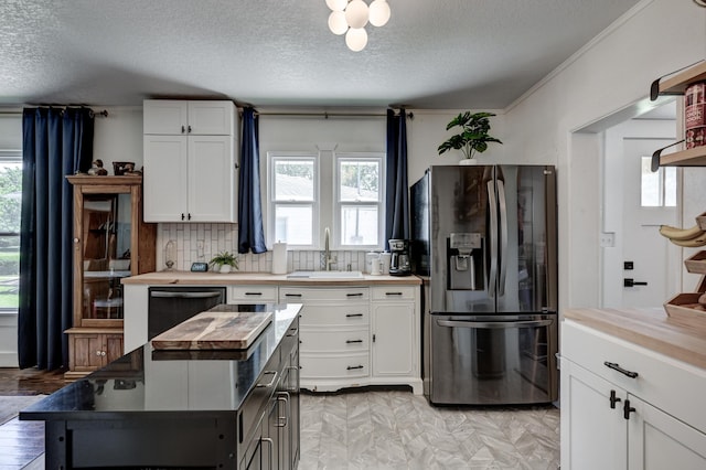 1508 S Moffet Ave, Joplin, MO 64804 - kitchen featuring fridge with ice dispenser, a textured ceiling, wooden counters, white cabinets, and dishwashing machine