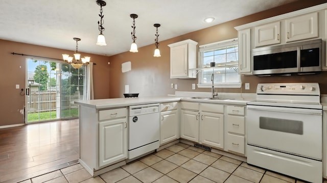 205 W Hunter Dr, Nixa, MO 65714 - kitchen featuring white appliances, healthy amount of natural light, a peninsula, a chandelier, and recessed lighting