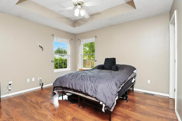 205 W Hunter Dr, Nixa, MO 65714 - bedroom with wood finished floors, a tray ceiling, and ceiling fan