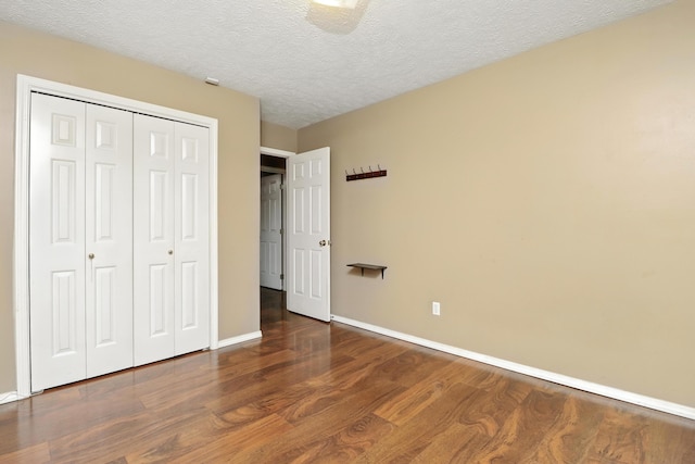 205 W Hunter Dr, Nixa, MO 65714 - unfurnished bedroom featuring wood finished floors, a closet, and a textured ceiling