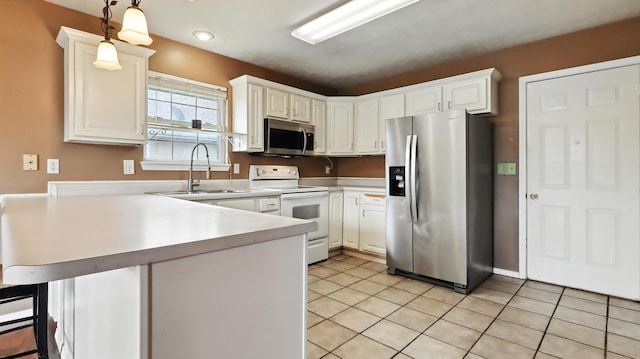 205 W Hunter Dr, Nixa, MO 65714 - kitchen with appliances with stainless steel finishes, a peninsula, light tile patterned floors, light countertops, and hanging light fixtures