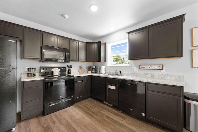 302 W College St, Branson, MO 65616 - kitchen with black appliances, wood finished floors, dark brown cabinetry, light stone counters, and recessed lighting