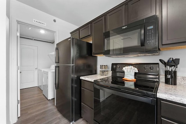302 W College St, Branson, MO 65616 - kitchen with black appliances, washer and clothes dryer, wood finished floors, dark brown cabinets, and light stone counters