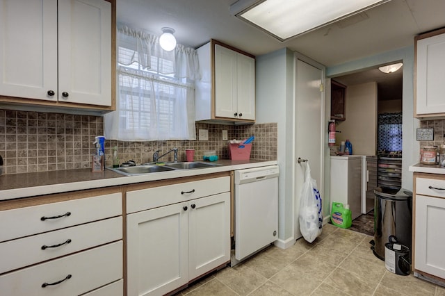 1027 S Orner St, Carthage, MO 64836 - kitchen with white dishwasher, tasteful backsplash, light tile patterned floors, washer / dryer, and white cabinets