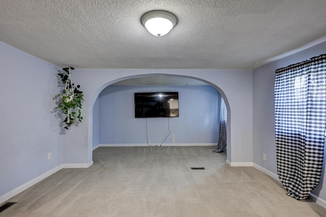 1027 S Orner St, Carthage, MO 64836 - unfurnished room featuring arched walkways, carpet, and a textured ceiling