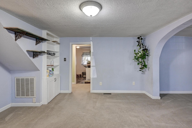 1027 S Orner St, Carthage, MO 64836 - unfurnished room with light carpet, arched walkways, a textured ceiling, and built in shelves