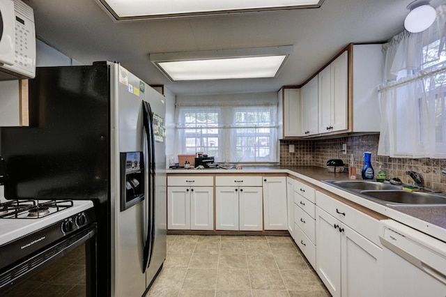 1027 S Orner St, Carthage, MO 64836 - kitchen with white appliances, tasteful backsplash, white cabinets, and light tile patterned floors