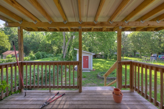 1027 S Orner St, Carthage, MO 64836 - wooden deck with a yard, a storage unit, and view of wooded area