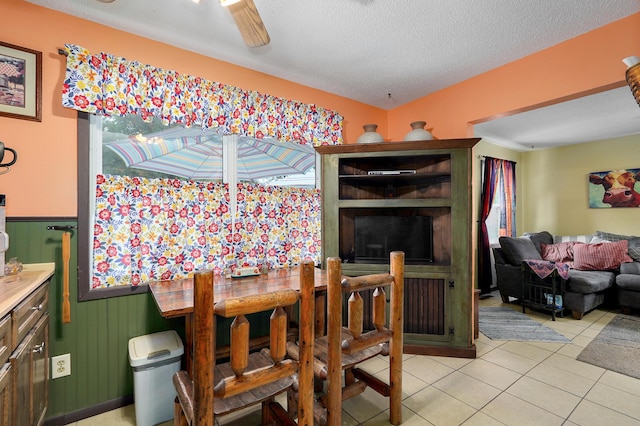 1648 N Yates Ave, Springfield, MO 65803 - dining room featuring light tile patterned flooring, a textured ceiling, and a wainscoted wall