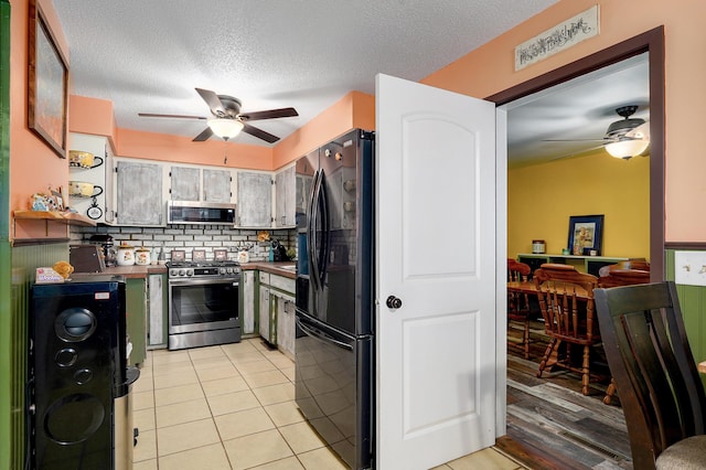 1648 N Yates Ave, Springfield, MO 65803 - kitchen with stainless steel appliances, a ceiling fan, backsplash, light tile patterned flooring, and a textured ceiling