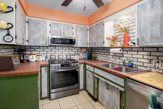 1648 N Yates Ave, Springfield, MO 65803 - kitchen featuring stainless steel appliances, tasteful backsplash, light tile patterned floors, ceiling fan, and a textured ceiling
