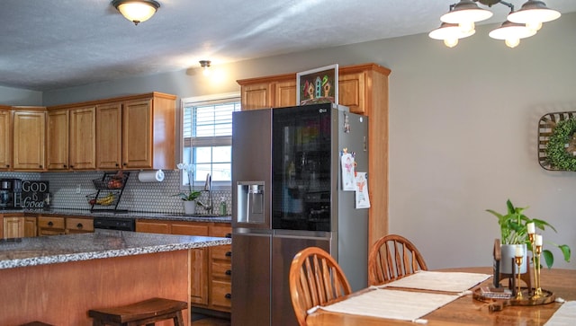 921 Woodhurst Dr, Marshfield, MO 65706 - kitchen with stainless steel fridge, tasteful backsplash, a chandelier, dishwasher, and brown cabinetry