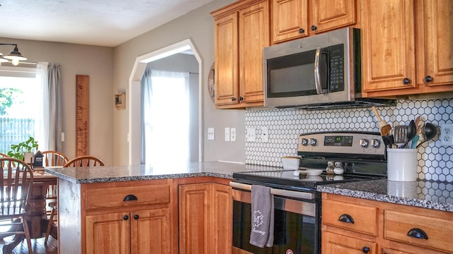921 Woodhurst Dr, Marshfield, MO 65706 - kitchen featuring stainless steel appliances, plenty of natural light, a peninsula, and decorative backsplash