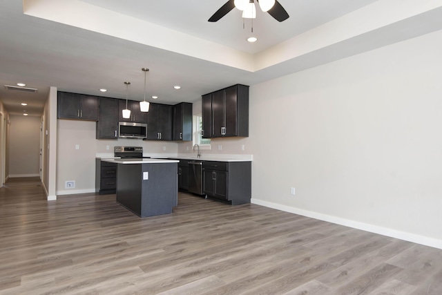 1851 N Patterson Ave, Springfield, MO 65803 - kitchen with appliances with stainless steel finishes, open floor plan, light countertops, light wood-style floors, and a kitchen island