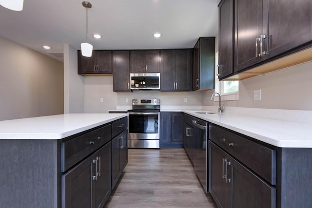 1851 N Patterson Ave, Springfield, MO 65803 - kitchen featuring appliances with stainless steel finishes, light wood-style floors, pendant lighting, dark brown cabinetry, and recessed lighting