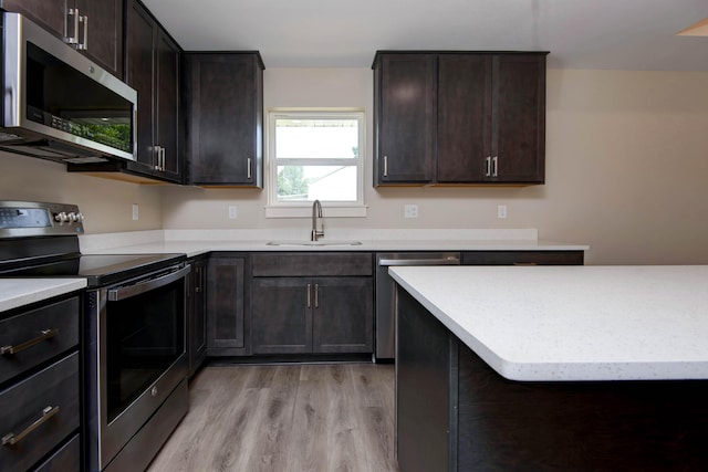 1851 N Patterson Ave, Springfield, MO 65803 - kitchen with appliances with stainless steel finishes, light wood-style flooring, light countertops, and dark brown cabinets