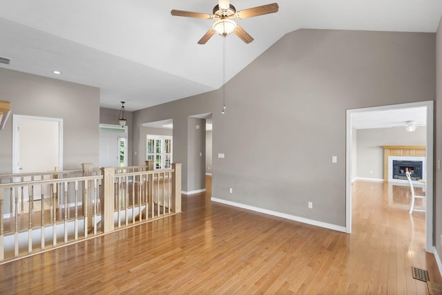 169 Tanner Rd, Branson, MO 65616 - unfurnished room featuring a ceiling fan, wood finished floors, a glass covered fireplace, high vaulted ceiling, and recessed lighting