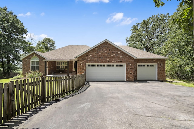 169 Tanner Rd, Branson, MO 65616 - single story home with driveway, a fenced front yard, a garage, and brick siding