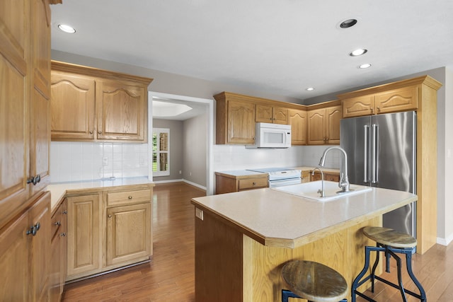 169 Tanner Rd, Branson, MO 65616 - kitchen featuring white microwave, high quality fridge, a kitchen island with sink, a breakfast bar, and light countertops