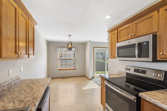 421 W White Ash Rd, Nixa, MO 65714 - kitchen with appliances with stainless steel finishes, brown cabinets, a chandelier, decorative light fixtures, and light flooring