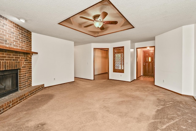 3642 N Olive Ct, Springfield, MO 65803 - unfurnished living room featuring ceiling fan, a textured ceiling, carpet floors, a fireplace, and a tray ceiling