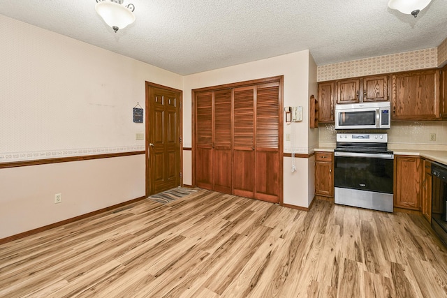 3642 N Olive Ct, Springfield, MO 65803 - kitchen featuring light wood-style floors, stainless steel appliances, light countertops, a textured ceiling, and brown cabinets