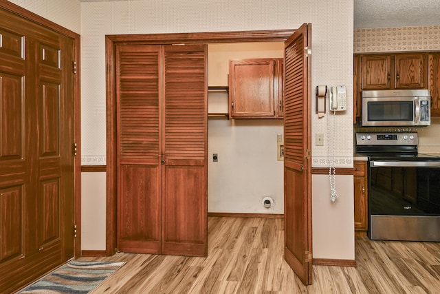 3642 N Olive Ct, Springfield, MO 65803 - kitchen featuring appliances with stainless steel finishes, light wood-type flooring, wallpapered walls, and light countertops