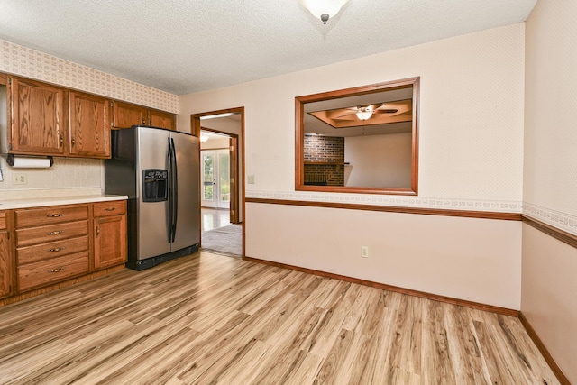 3642 N Olive Ct, Springfield, MO 65803 - kitchen with light wood-style floors, stainless steel fridge with ice dispenser, brown cabinets, light countertops, and a textured ceiling