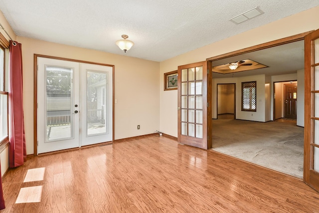 3642 N Olive Ct, Springfield, MO 65803 - empty room with french doors, wood finished floors, a textured ceiling, and a ceiling fan