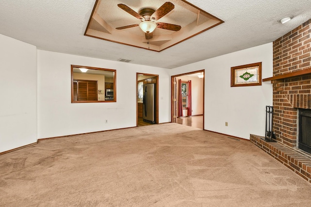 3642 N Olive Ct, Springfield, MO 65803 - unfurnished living room featuring ceiling fan, carpet, a brick fireplace, a textured ceiling, and a raised ceiling