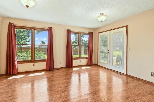 3642 N Olive Ct, Springfield, MO 65803 - unfurnished room with plenty of natural light, a textured ceiling, wood finished floors, and french doors