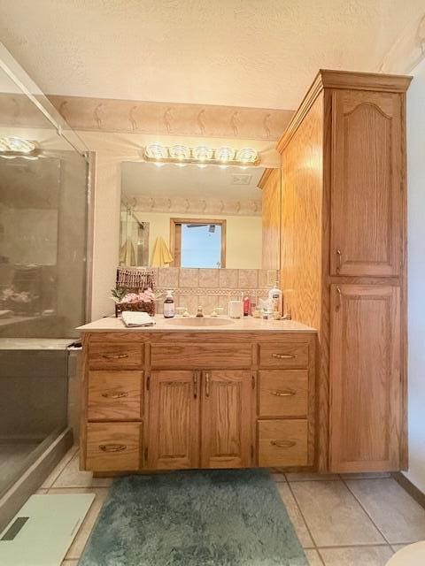 3086 S Suburban Ave, Springfield, MO 65807 - bathroom featuring vanity, a stall shower, tile patterned floors, and decorative backsplash