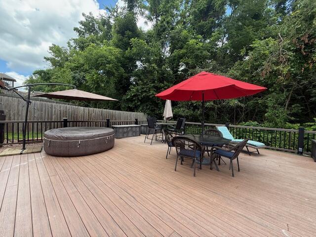 3086 S Suburban Ave, Springfield, MO 65807 - wooden deck featuring a hot tub, outdoor dining area, and a fenced backyard