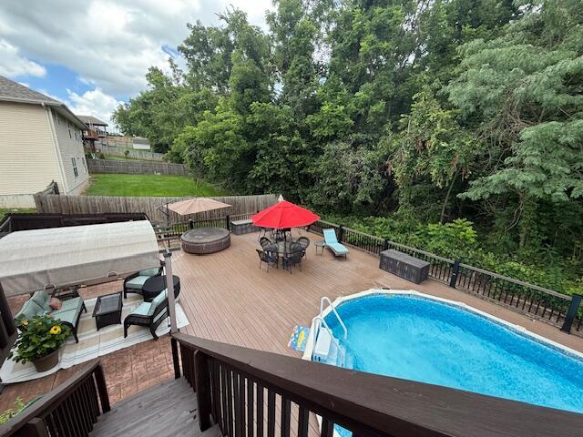 3086 S Suburban Ave, Springfield, MO 65807 - view of swimming pool featuring outdoor dining space, a deck, and a fenced backyard